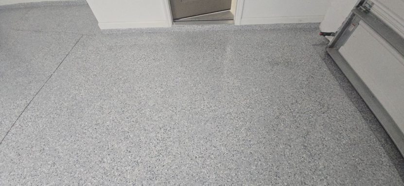 Gray speckled flooring with a doorway visible in the background.