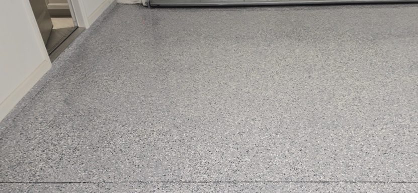 Gray epoxy flooring with a speckled texture and a glossy finish.